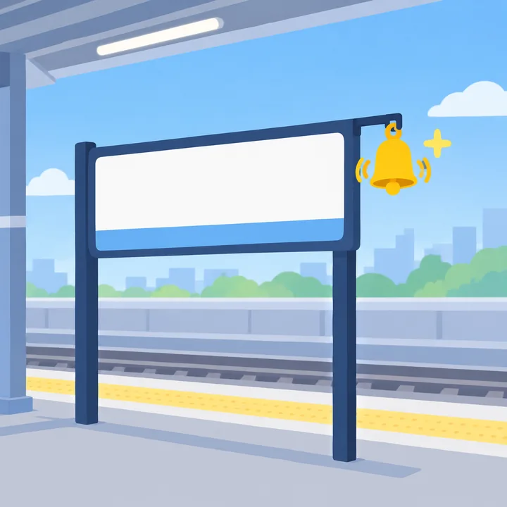 A blank station sign on a platform, with a yellow bell hanging from it